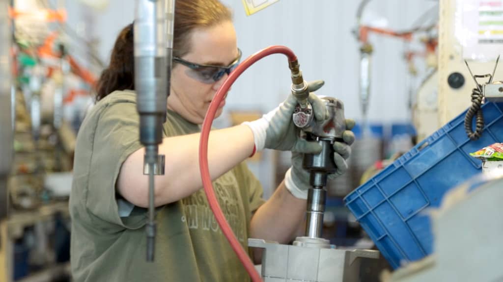 Prestolite female worker assembling an alternator at the plant.
